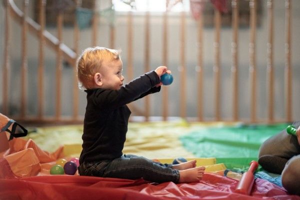 atragantamiento - niño jugando con un adulto dentro de una zona de juego con juguetes