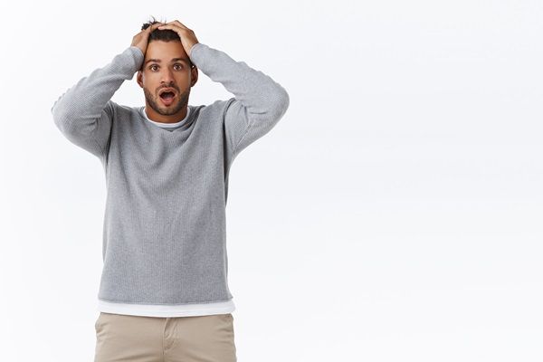 Azoospermia - Hombre joven poniendo las manos en la cabeza con cara de asombro