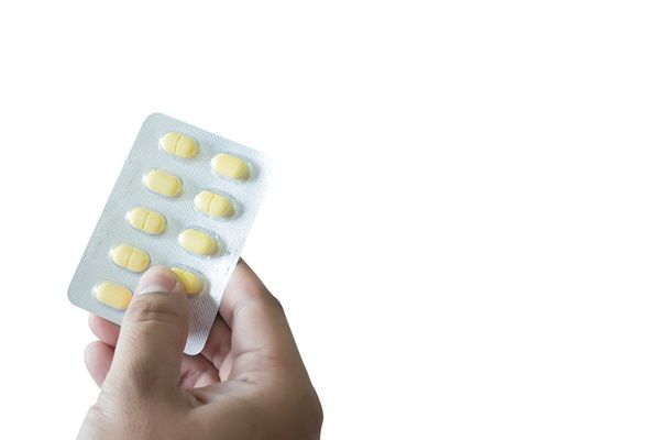 Mano de una persona sosteniendo un paquete de pastillas