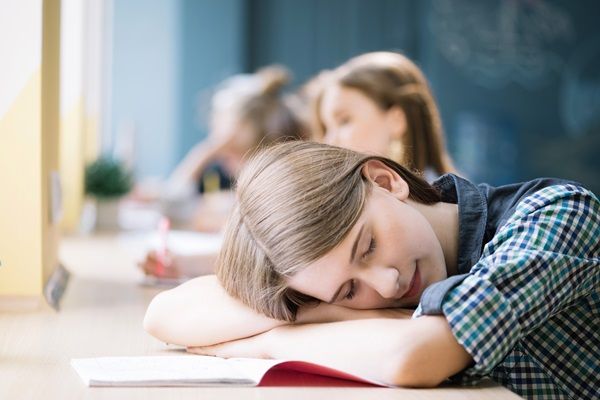 Cataplexia - Mujer joven con los ojos cerrados descansando sobre un escritorio