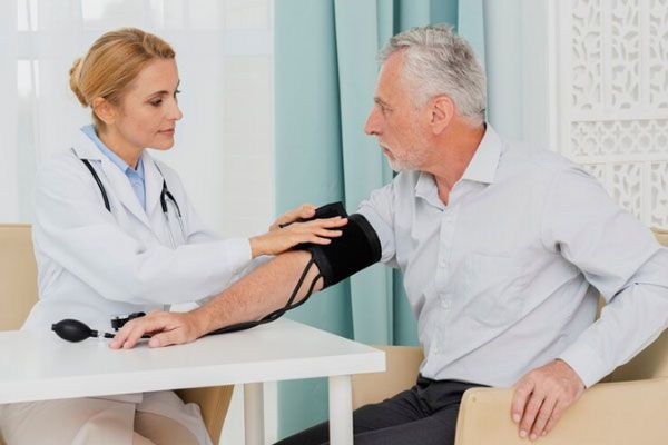 Parálisis del sueño - Doctora examina y le toma la presión arterial a un hombre de edad avanzada 