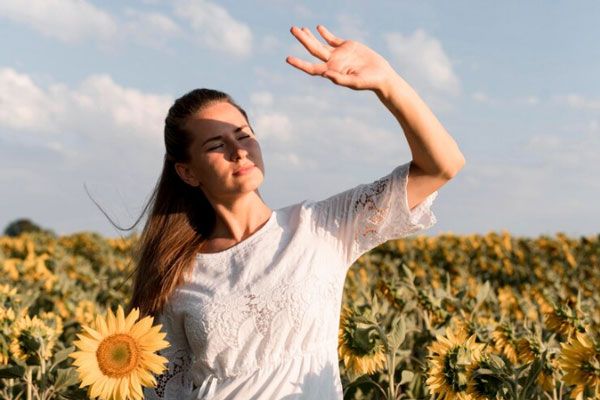 Nistagmo - Mujer con sensibilidad a la luz levanta su mano para proteger la vista del sol
