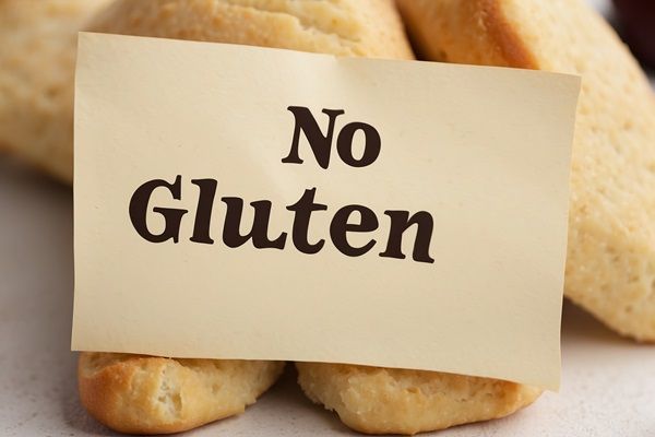 Celiaquía o intolerancia al gluten - Letrero de no gluten sobre unas barras de pan especial para celíacos