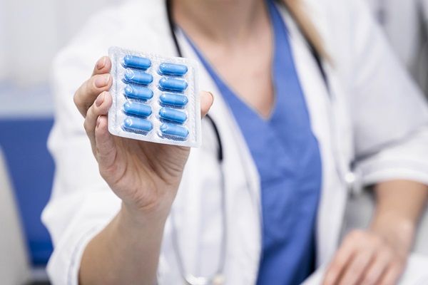 Vivir con la enfermedad de Addison - Doctora mostrando en sus manos un paquete de pastillas hormonales de color azul