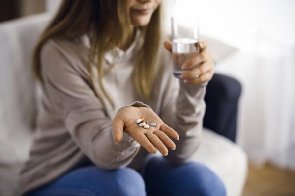 Mujer con mano extendida toma antipsicóticos para controlar los síntomas de una enfermedad mental 