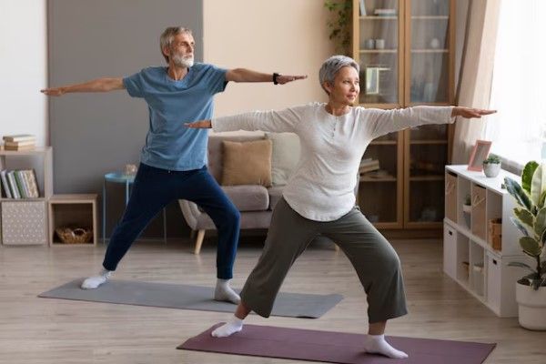 pareja de personas mayores haciendo yoga para reducir los niveles de estrés