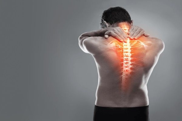 Espondilitis anquilosante esperanza de vida - Hombre de espalda con una representación gráfica de la columna vertebral