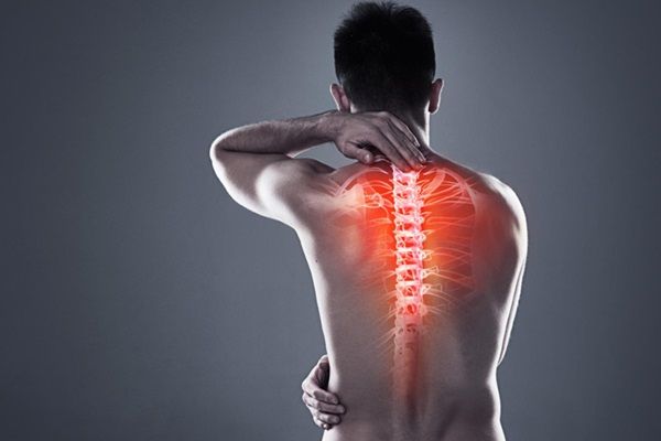Espondilitis anquilosante esperanza de vida - Hombre tocándose con las manos la espalda con dibujo de la columna vertebral