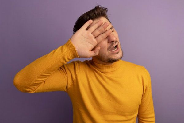 Blefaritis - Hombre con irritación en la vista pasa su mano por la cara y evita el contacto directo con los dedos
