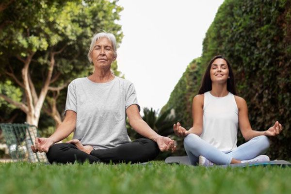 Dermatitis por estrés - Mujeres practican yoga al aire libre para tener un mayor control de las emociones
