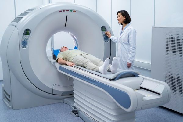 Doctora realizando un estudio de resonancia magnética a un paciente hombre
