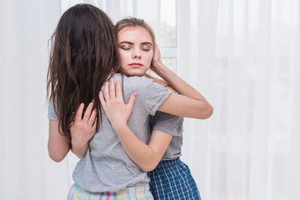 Autolesión - Joven abraza a una amiga con depresión para brindarle apoyo emocional
