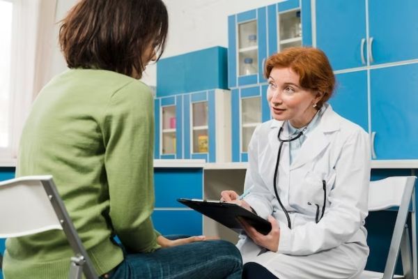 Síntomas de la nueva variante del COVID EG.5 - medico examinando a una paciente en busca de alguno de los síntomas de la nueva variante del COVID EG.5