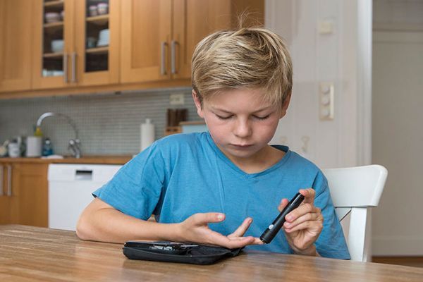 Niño con diabetes midiendo su glucosa
