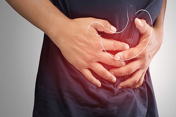 Hombre tocándose el abdomen, reflejando molestias en su sistema digestivo
