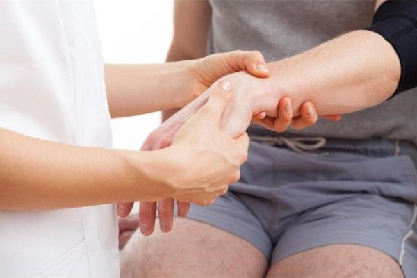 Fractura del escafoides - medico revisando la muñeca de un paciente tras haber sufrido este ultimo un golpe
