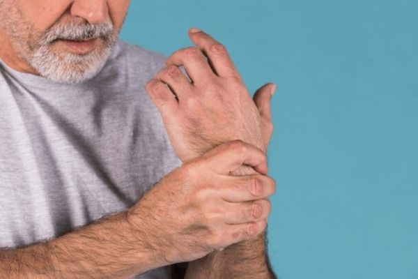 hombre adulto agarrado su muñeca dolorida