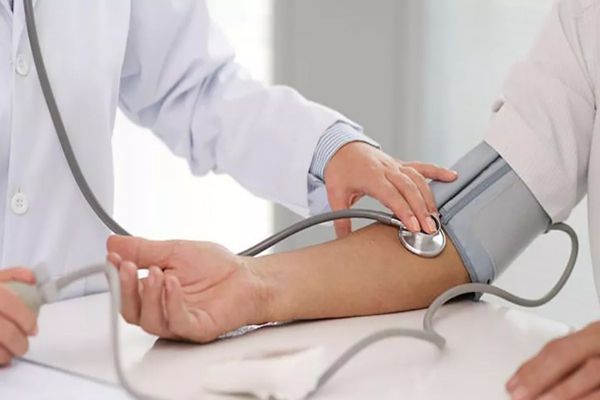 Médico tomando la presión a paciente femenina