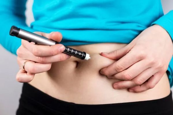 chica colocandose inyección de insulina