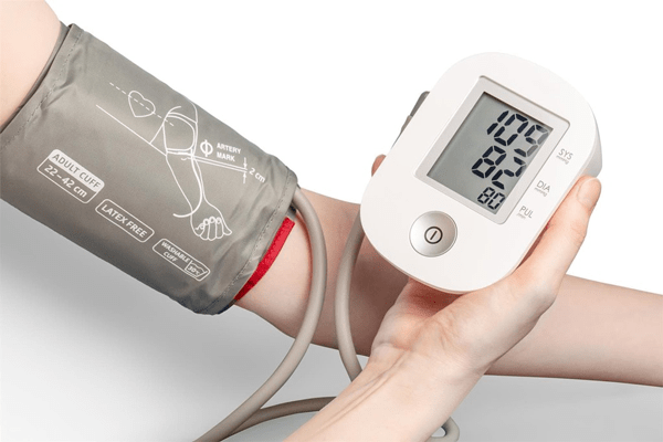 Colesterol bueno y malo - Persona controlando su presión arterial para monitorear su salud cardiovascular