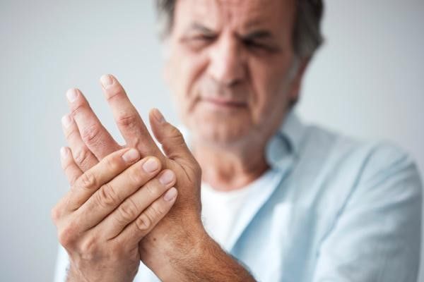 Metacarpianos y falanges - hombre mayor sujetándose la mano con cara de dolor por una posible fractura