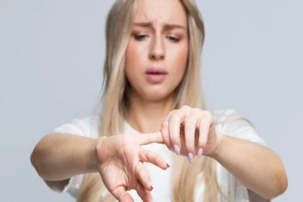 Metacarpianos y falanges - mujer con cara de dolor al intentar mover la falange de un dedo