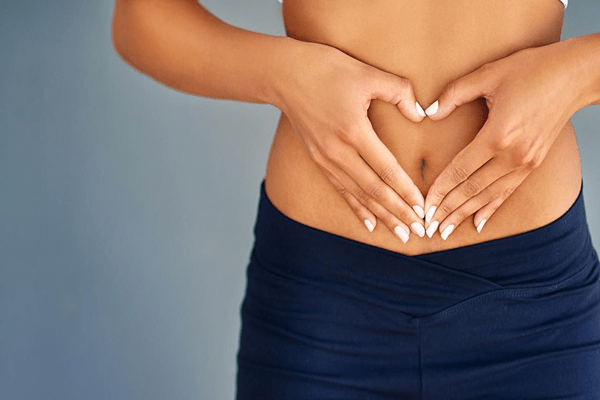 Motilidad intestinal - Persona formando un corazón sobre el abdomen, simbolizando el cuidado de la salud digestiva y la regularidad intestinal