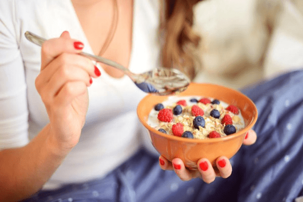 Persona con taza de frutos secos en sus manos demostrando como la alimentación mejora la regularidad intestinal