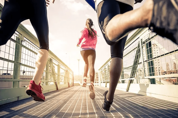 Una mujer corriendo al aire libre, ejercitándose en un día soleado, puede reducir el riesgo de enfermedades cardíacas.