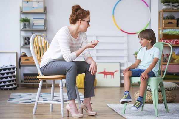 maestra hablando con un niño de edad escolar