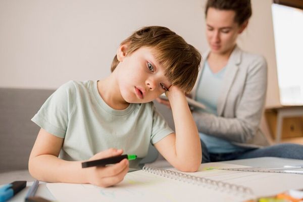 TDAH - niño distraido mientras hace la tarea