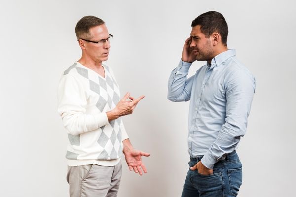 hombre acostumbrado a mentir, hablando con alguien que se ve molesto