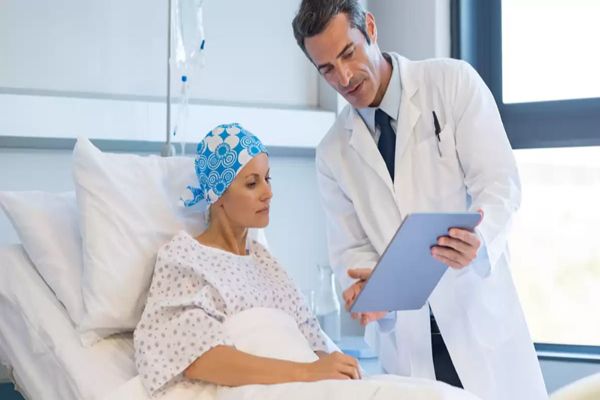 Trasplante de médula ósea - Paciente con cáncer conversa con su médico mientras recibe tratamiento