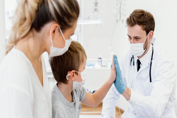 Trasplante de médula ósea - Niño enfermo choca la mano con el pediatra como señal de que todo estará bien