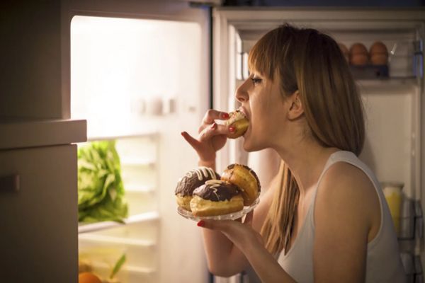 Tipos de trastornos alimenticios - Mujer comiendo a escondidas por la noche