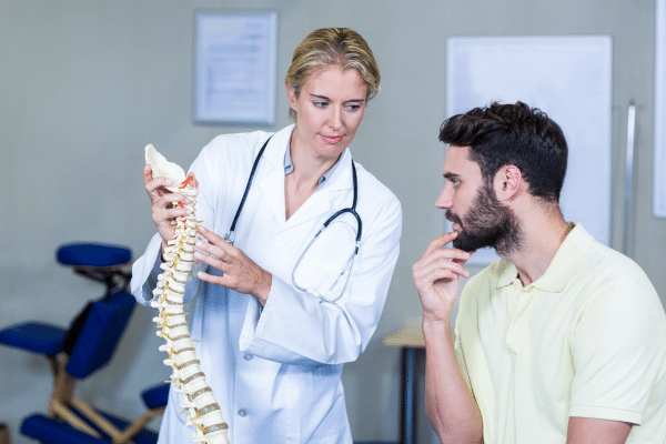 Médula ósea - Doctora explica a un paciente la composición y el funcionamiento de la columna vertebral