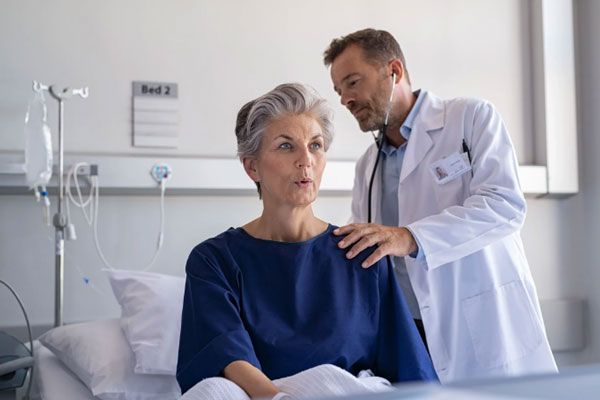 Staphylococcus aureus - Doctor examina los pulmones de una paciente de edad avanzada con problemas respiratorios