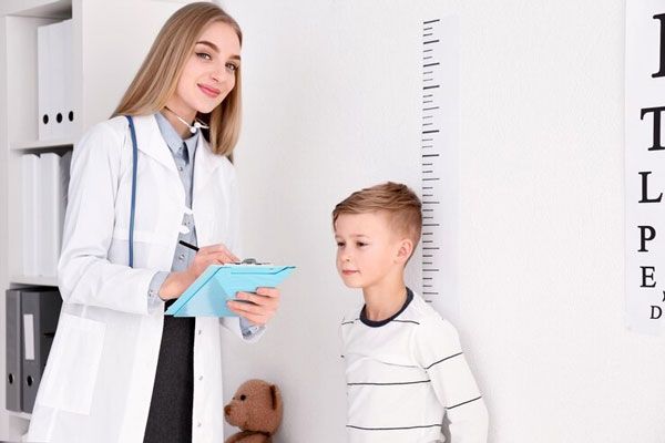 Osteogénesis - Doctora toma nota de los datos de un paciente tras chequear como está de altura
