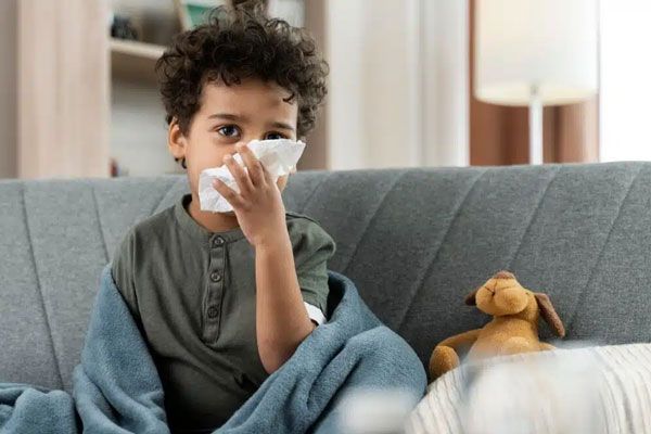 Sarampión - Niño con síntomas de resfriado se sacude la nariz para sentirse mejor