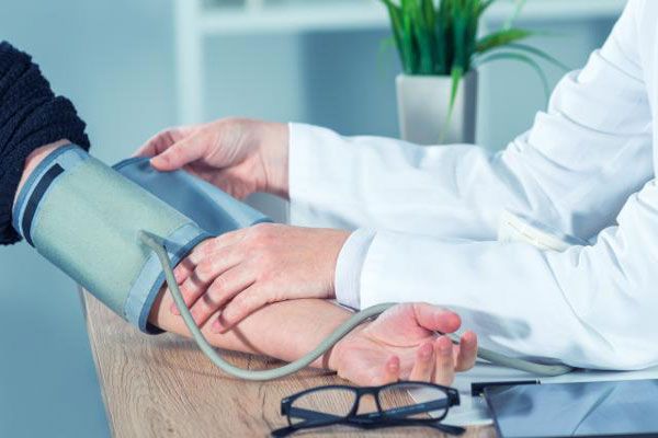 Staphylococcus aureus - Profesional de la salud le toma la presión arterial a un paciente en su consultorio