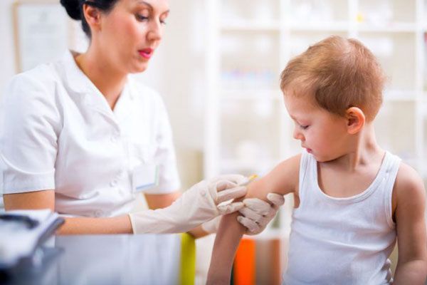 Enfermera aplica la segunda dosis del esquema de vacunación a un niño de 5 años