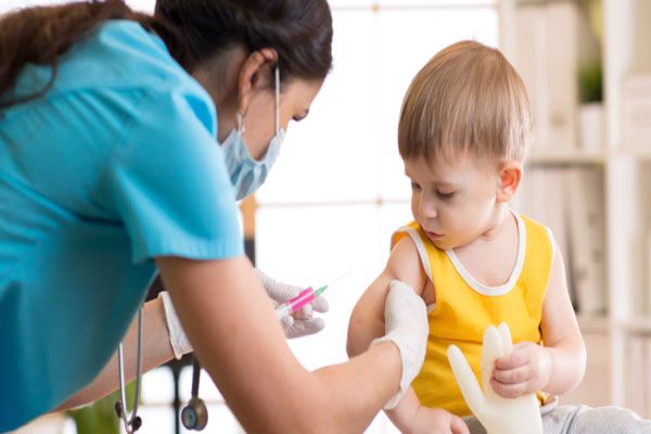 Profesional de la salud aplica vacuna para inmunizar a un niño pequeño contra múltiples virus y enfermedades