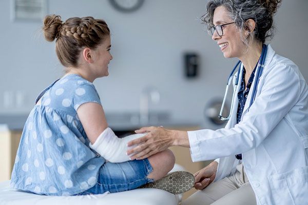 Osteogénesis - Doctora habla con una paciente para explicarle como debe cuidar su yeso tras un fractura 
