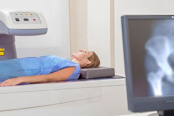 Densidad ósea - Paciente se prepara para la realización de una prueba de densintometría ósea 