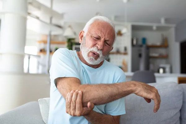Osteomielitis - Adulto mayor sostiene su codo tras punzante dolor