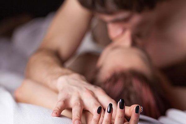 Tipos de hepatitis - Pareja se toma de la mano mientras sostienen relaciones sexuales de manera consensuada