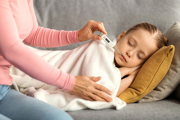 Madre le toma la temperatura a su hija tras presentar síntomas de malestar general
