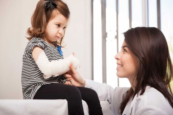 Osteogénesis imperfecta - Pediatra asiste a una niña con leve fractura en el brazo