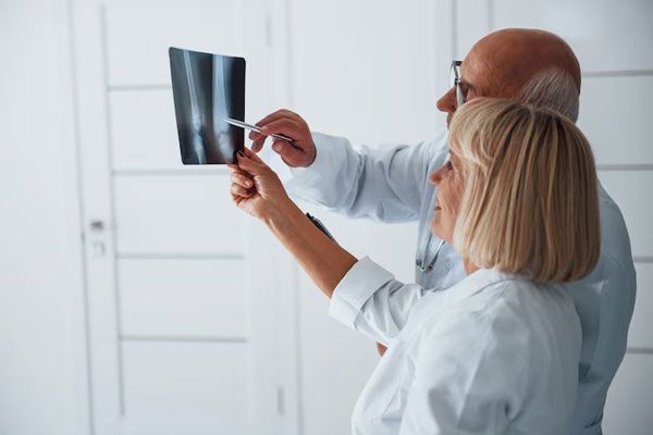 Doctores analizan la recuperación del hueso de un paciente mediante radiografía