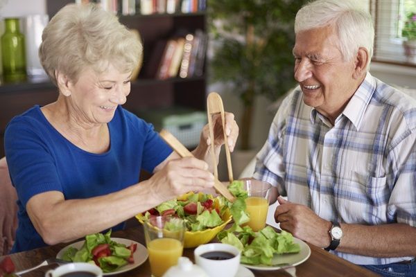 Pareja de adultos mayores comiendo de manera saludable, para consumir vitaminas y minerales que ayudan a fortalecer los huesos